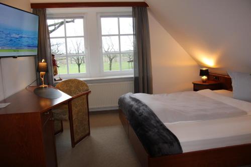 朗根哈根Landhaus am Golfpark的酒店客房设有一张床、一张书桌和窗户。