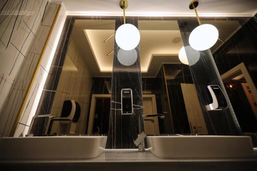 北马马亚-讷沃达里Hotel Grand Dedal的浴室在镜子前设有两个水槽
