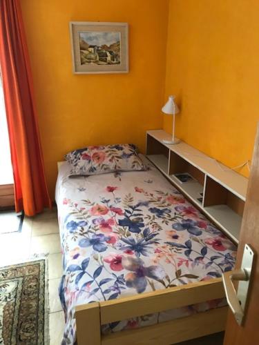 戈尔多拉Verzaschina的一间卧室配有一张带花卉床罩的床