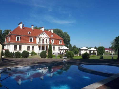 Svente斯文特斯穆伊札酒店的一座大房子,前面设有一个游泳池