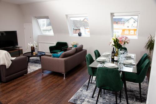 史云顿High Life Serviced Apartments - Old Town的客厅配有桌子和绿色椅子