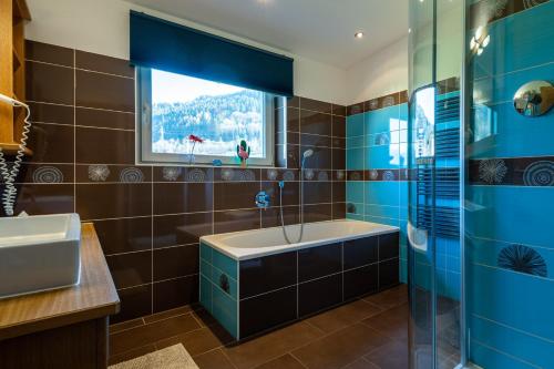 卡普伦Elinas Mountain Views的带浴缸、水槽和窗户的浴室