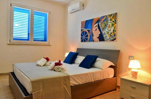 法维尼亚纳Casa Nettuno Favignana的一间卧室配有一张带蓝色和白色枕头的床