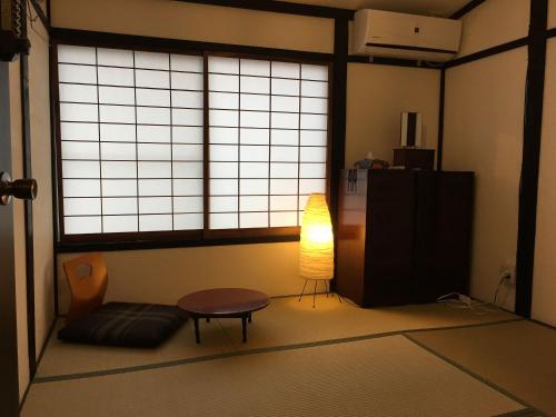 松江市Shikkuinoyado Tenjin的一间房间,里面设有一张桌子和一盏灯