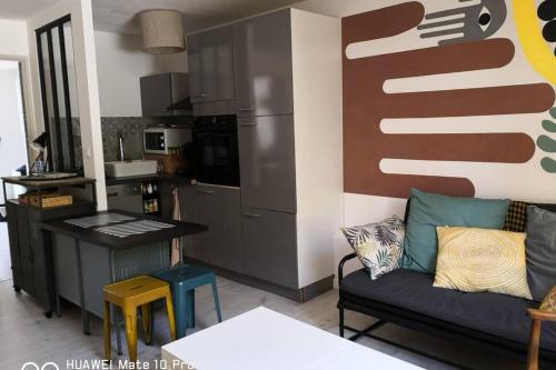 耶尔Appartement avec Jardin privatif centre ville的带沙发的客厅和厨房