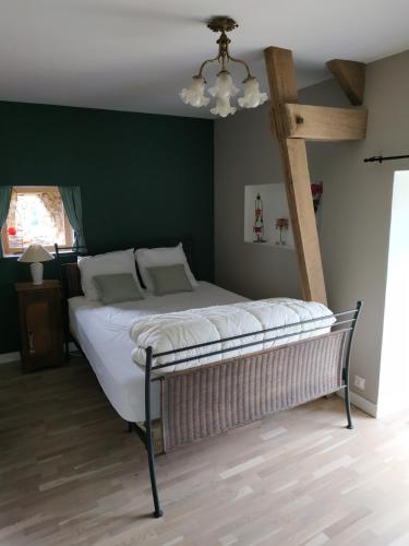 Val CouesnonLa maison à Jean的卧室内的一张床位,卧室设有绿色的墙壁