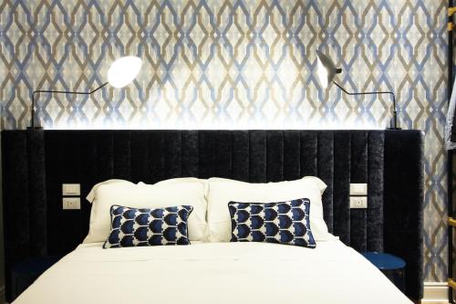 的里雅斯特Le Porte Blu的卧室配有带枕头的黑白床。