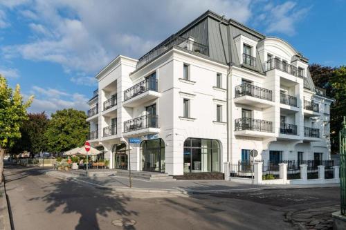 米兹多洛杰Luxury Apartments in Residence Maritime的白色的建筑,在街上设有阳台