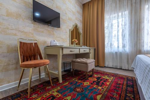 巴库NAR BOUTIQUE HOTEL的酒店的客房,配有书桌和墙上的电视