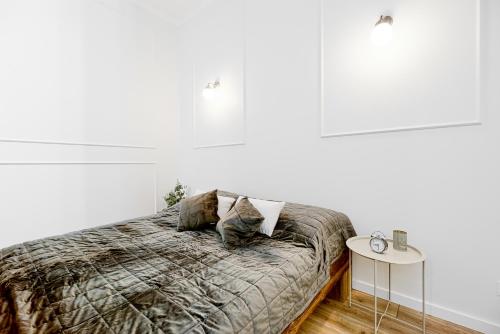 皮拉Niron Apartament Dom z Papieru Sztokholm的一间卧室设有一张床和白色的墙壁