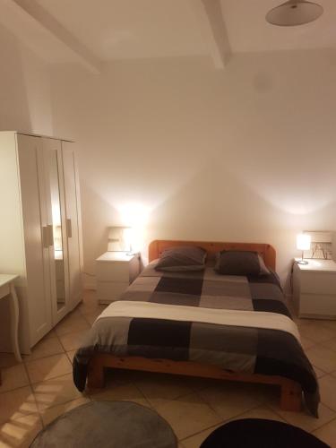 维特罗勒Maison à la semaine的一间卧室配有一张带2个床头柜的大床