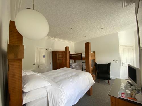 凯西克36号酒店的卧室配有白色的床和带电视的书桌。