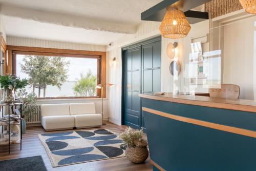 圣特罗让莱班Le Homard Bleu的客厅设有蓝色的柜台和窗户。