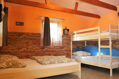 赞考Eszter Nyaralóház的一间卧室设有两张双层床和砖墙