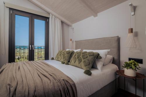 卡利地亚Villa Verde的一间卧室设有一张大床和大窗户