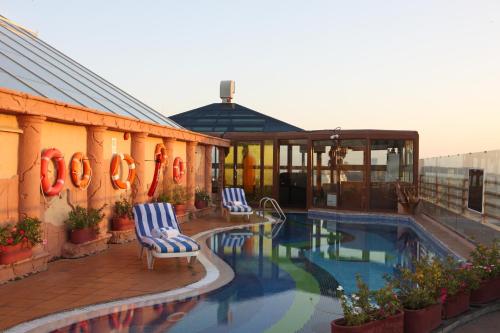 迪拜迪拜海景酒店的一座带两把椅子的游泳池位于大楼旁