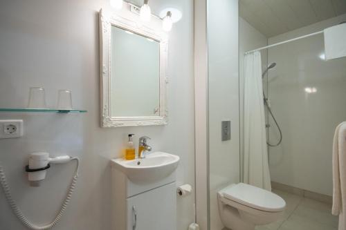 维克Hótel Búrfell的白色的浴室设有卫生间和水槽。