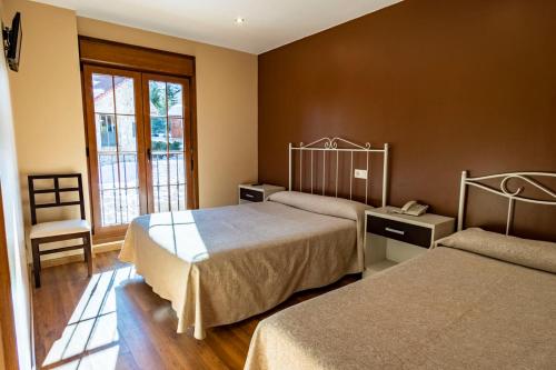圣伊西德罗Complejo Hotelero La Braña的酒店客房,配有两张床和椅子