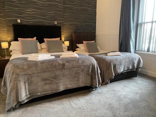 牛顿斯图尔特王冠酒店的配有衬衫的酒店客房内的两张床