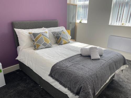 韦克菲尔德2B SPV Double En-suite Room的卧室配有一张带白色床单和枕头的大床。
