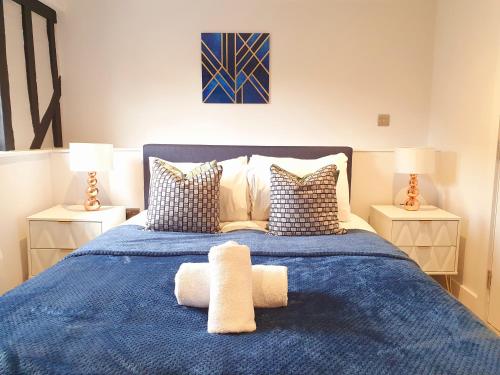 彼索普斯托福Stansted Airport Luxury Apartment Bishops Stortford Millars One Loft 4的一间卧室配有一张带两盏灯的蓝色床。
