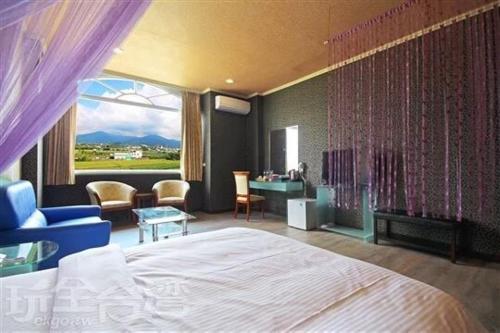 埔里華秝茶油幸福莊園的一间卧室配有一张床,另一间享有美景。
