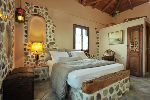 加拉希德松阿康提克艺术酒店的一间卧室设有一张带石墙的大床