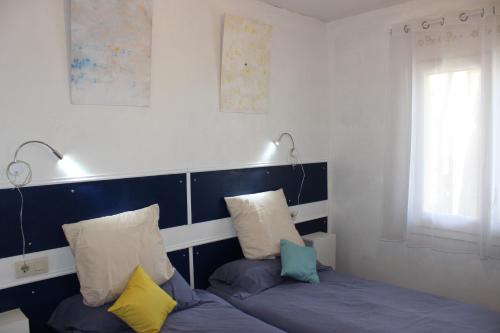 兰卡Luxury 4 bed apartment on coastal footpath at Cap Ras的客房设有带2个枕头的床和窗户。