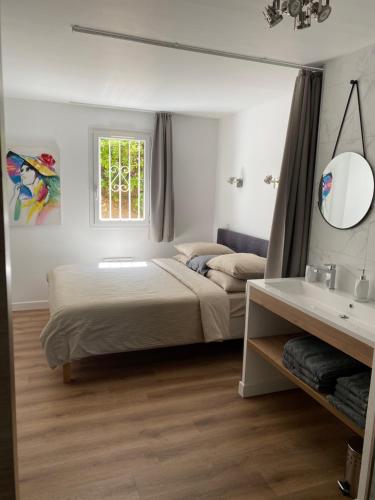 格里莫Domaine des Restanques, suite parentale ,vue mer.的一间卧室配有床、镜子和水槽