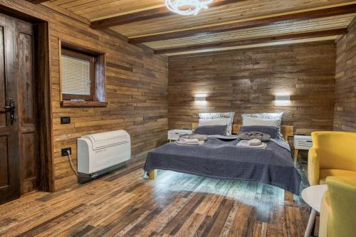 多博伊Ribarski konaci的一间卧室设有一张床和木墙