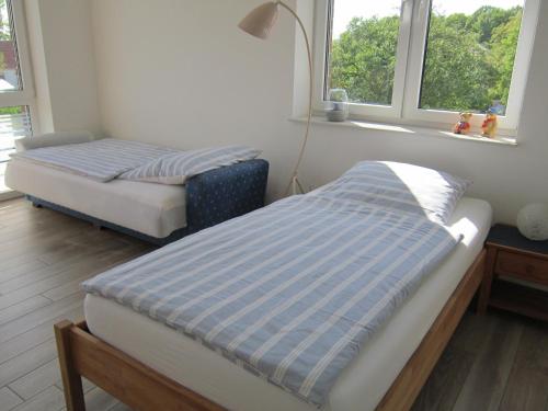 森登霍尔斯特Ferienwohnung de Jong的带2扇窗户的客房内的2张床
