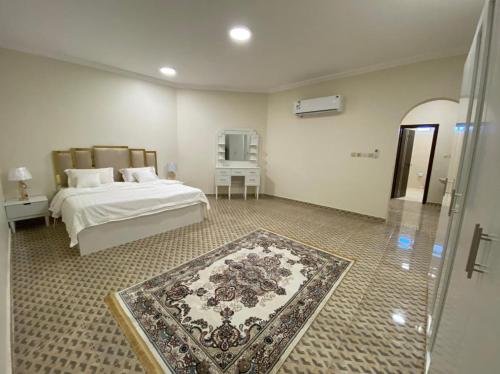 雷伊斯فيلا أمواج الشاطىء Amoaj beach的卧室配有一张床,地板上铺有地毯
