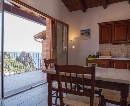 内比达La Casa Del Mare Tanca Piras的一个带桌子的厨房和一个享有阳台景色的厨房