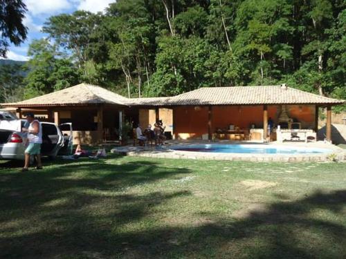 萨纳Recanto beira rio的一座带游泳池的房子,人们坐在院子里