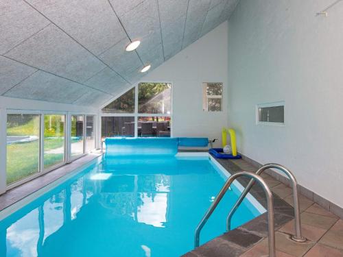 菲耶勒鲁普海滨12 person holiday home in Glesborg的大楼内的一个蓝色海水游泳池