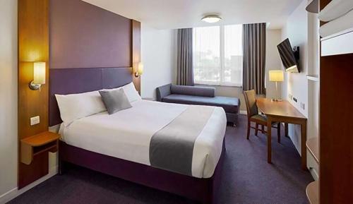 克努斯福德Casa Mere Manchester; Sure Hotel Collection by Best Western的酒店客房设有一张大床和一张书桌。