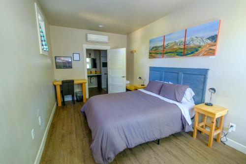 毕夏普Eastside Guesthouse and Bivy的一间卧室配有一张带紫色床罩的床