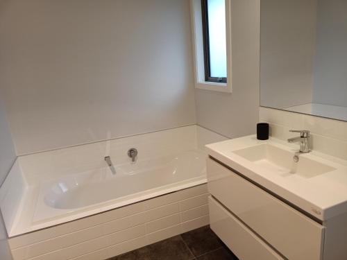 里士满Richmond, Nelson 3brm New Home的白色的浴室设有浴缸和两个盥洗盆