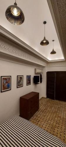 马拉喀什里亚德巴洛克旅馆的一间卧室配有床、两个灯和一台电视
