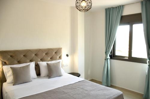 尼基季Theano Luxury Suites Nikiti的一间卧室设有一张大床和窗户
