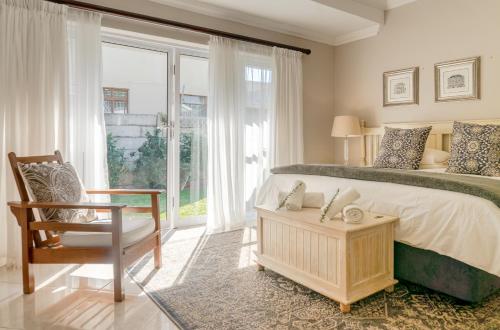 贝拉贝拉Bela Rini Guesthouse的卧室配有床、椅子和窗户。