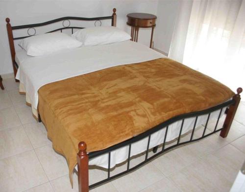 尼亚普拉莫斯To Portego tis Anatolis的一间卧室配有一张木架床和白色床单。