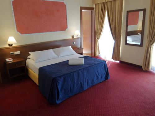 贝内文托Hotel Antiche Terme Benevento的酒店客房,配有一张带笔记本电脑的床
