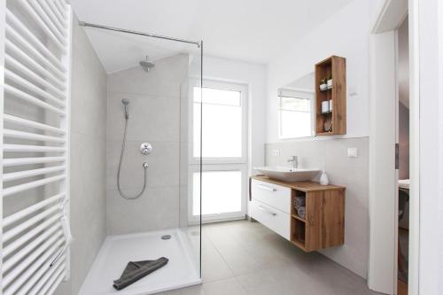 青斯特Blauwasser Luv的带淋浴和盥洗盆的白色浴室
