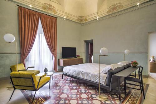 夏卡Regina Bianca - Camere, Suite & Spa - Sciacca的一间卧室配有一张床、一张桌子和一把椅子