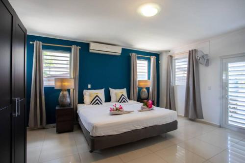 简蒂埃尔Villa Curazon met privézwembad vlakbij het strand!的一间卧室设有一张大床,拥有蓝色的墙壁和窗户。