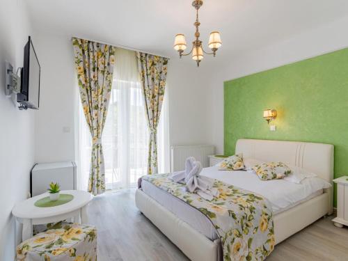 斯勒尼克Pensiunea Casuta cu Trandafiri 2的卧室配有白色的床和绿色的墙壁