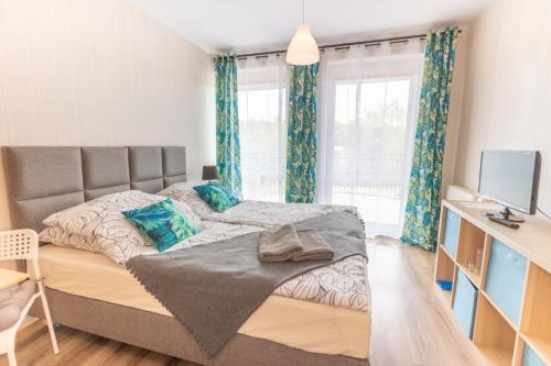 库瑞尼卡慕斯卡Maritima的一间卧室配有一张带蓝色窗帘的大床