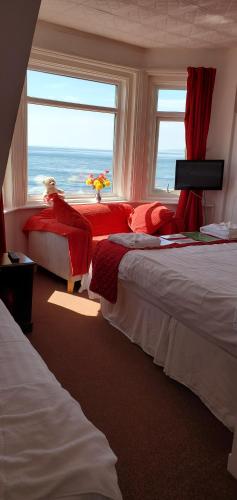 埃克斯茅斯Ash Hotel B&B的一间卧室设有两张床和一个海景窗户。