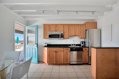 蒙托克漂流木海上度假酒店的厨房配有木制橱柜和不锈钢冰箱。